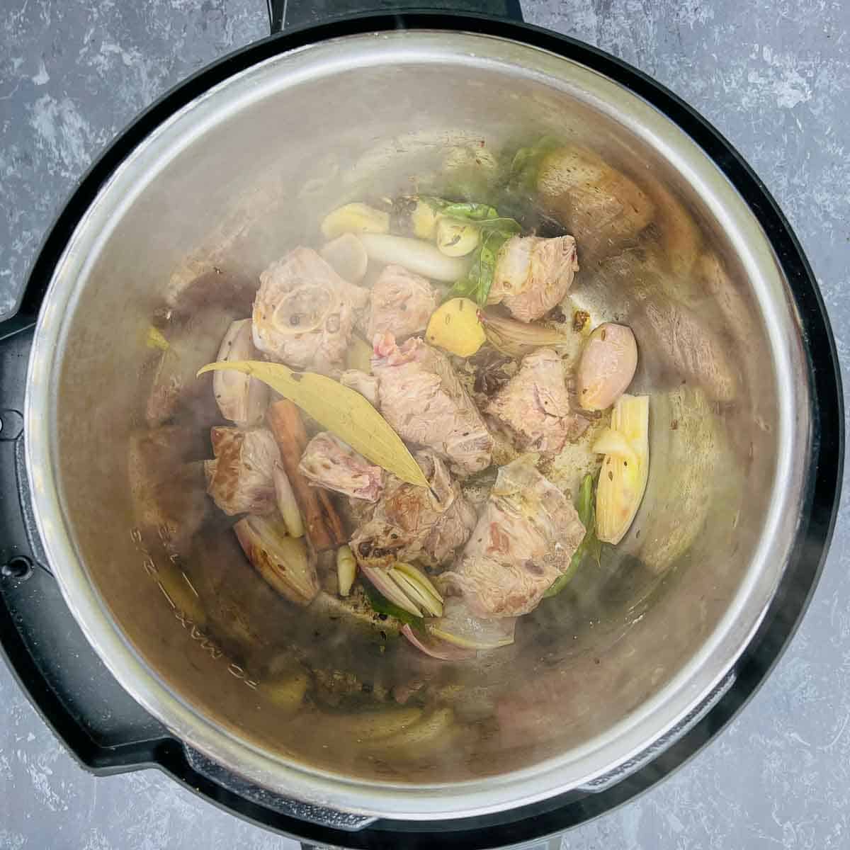 Step showing the browning of goat meat in the Instant Pot.