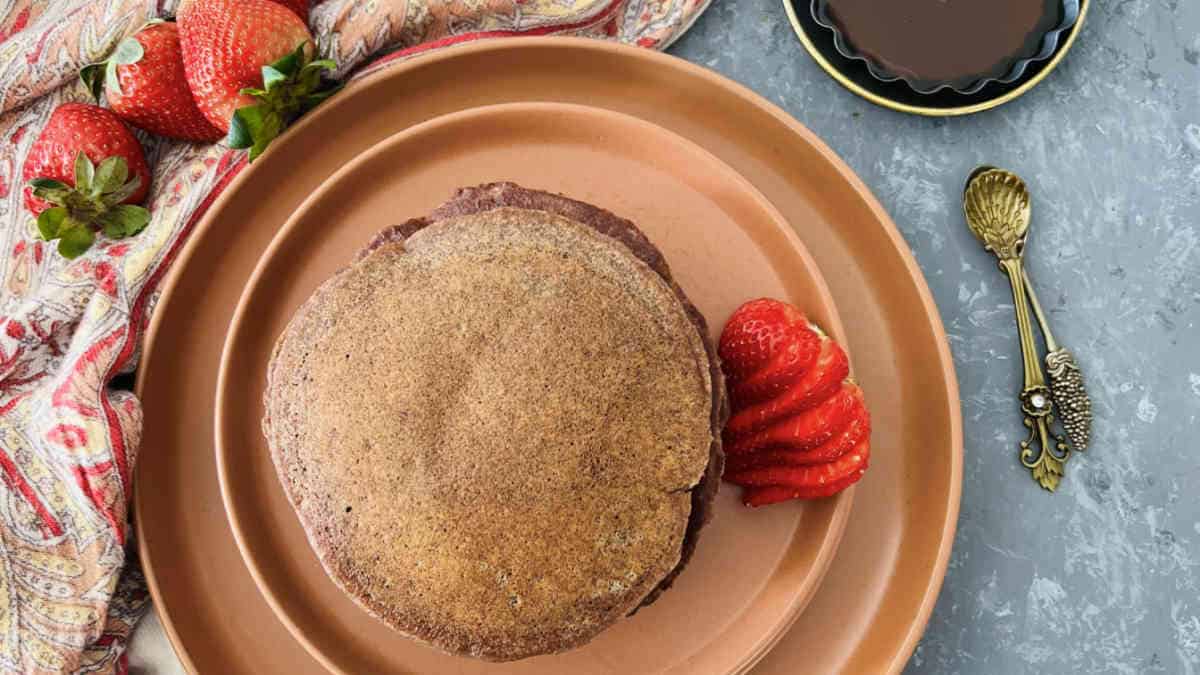 A stack of ragi pancakes placed on a brown plate.
