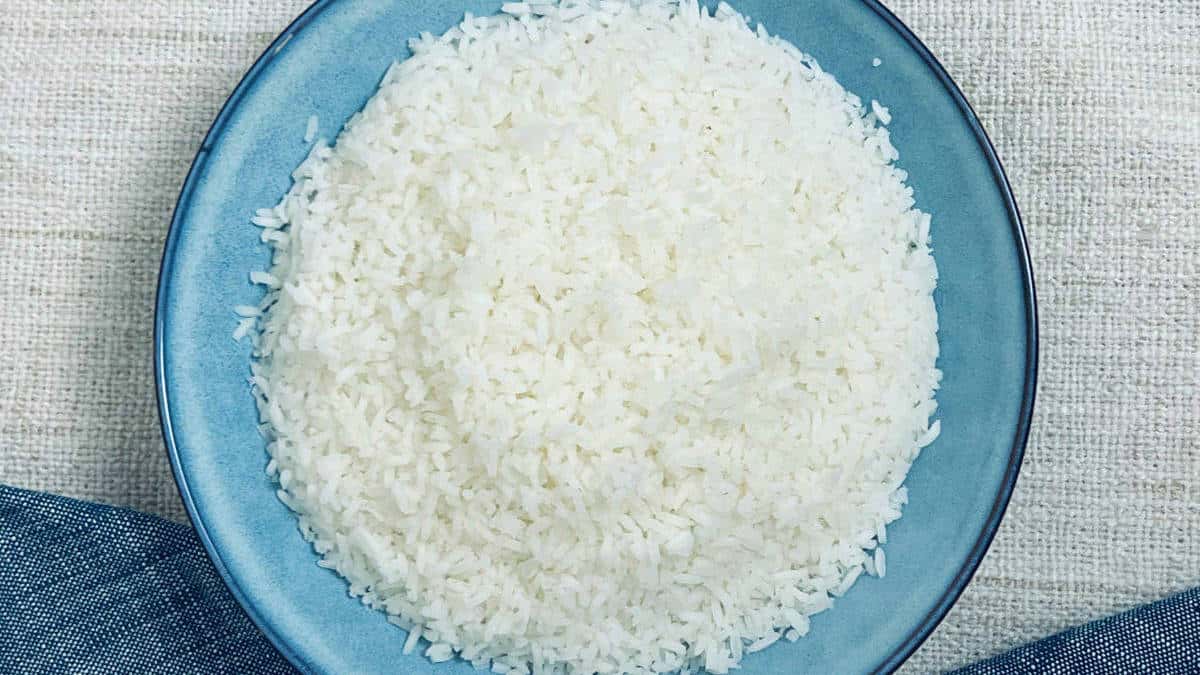 Cooked sona masoori rice on a blue plate.