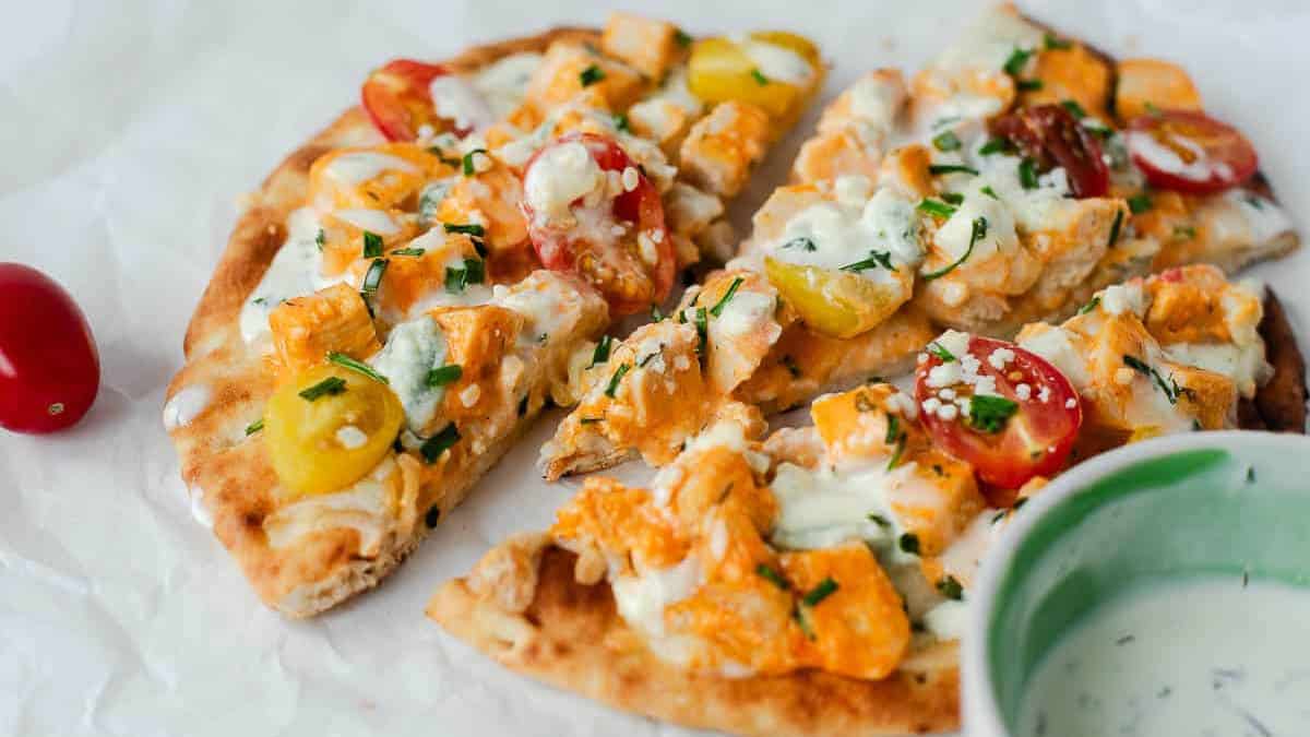 Slices of chicken pizza on a parchment paper.