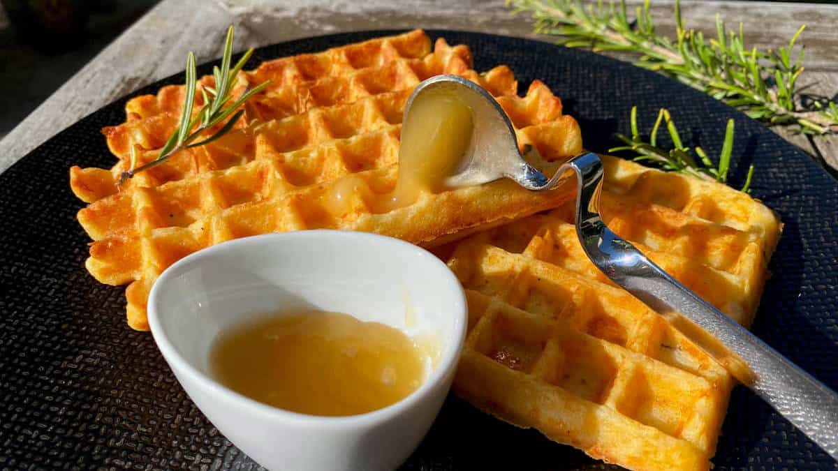 Cheese waffles on a black plate.