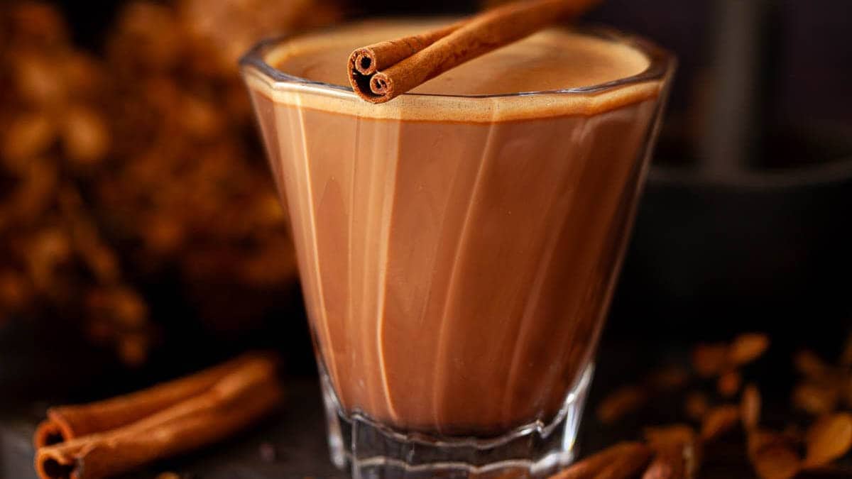 A glass of Mexican mocha with a cinnamon stick on top.