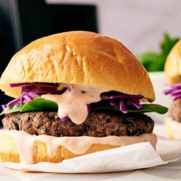 Two homemade black bean burgers in buns ready to eat.