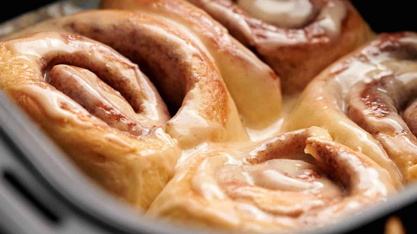 Air fried cinnamon rolls in an air fryer basket.