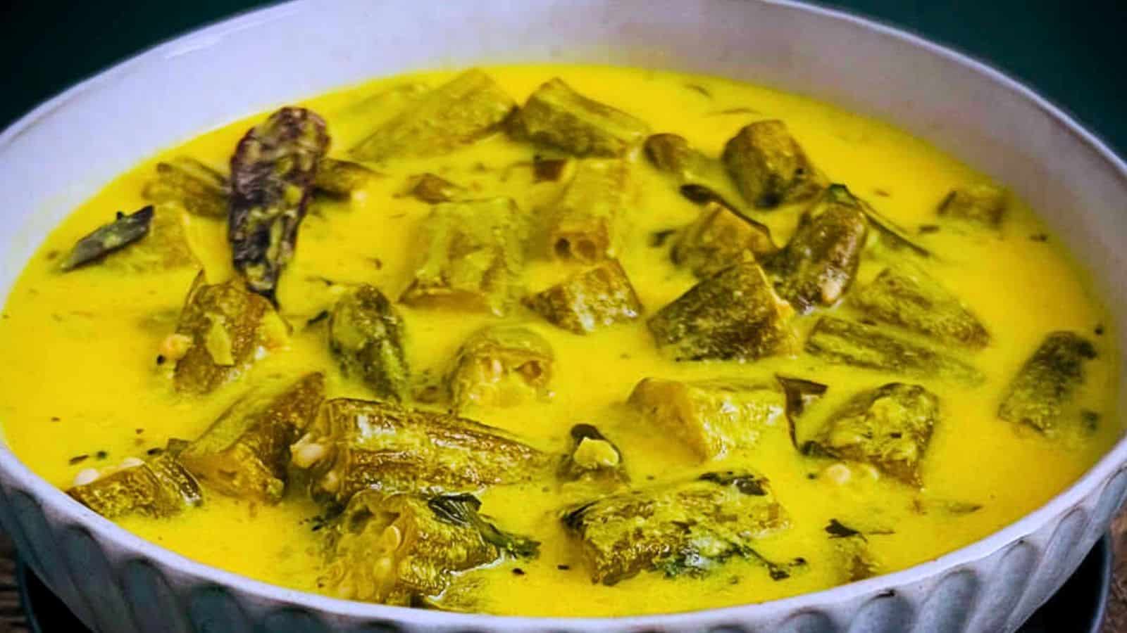 A bowl of Bhindi Kadhi with okra pieces in a creamy yellow sauce.