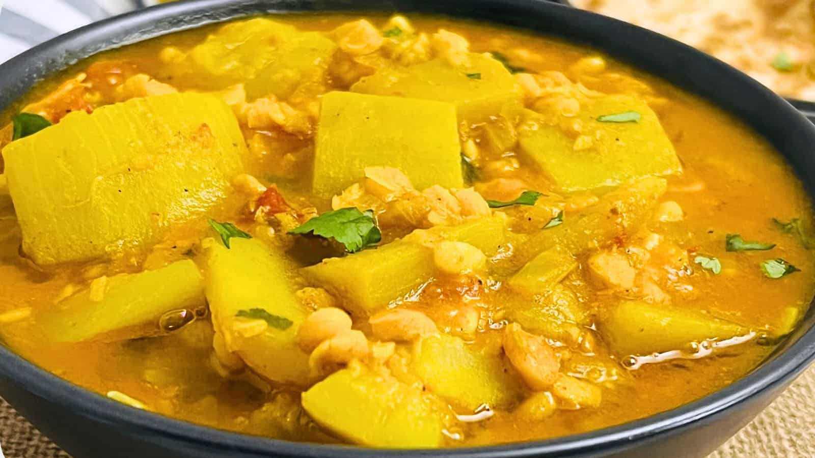 A bowl of Bottle Gourd Curry garnished with fresh cilantro.