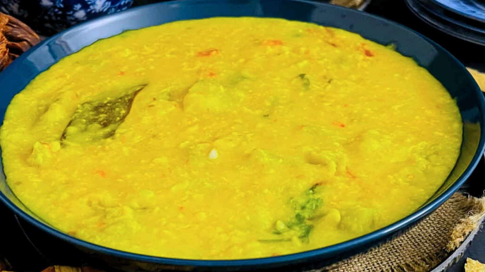 A bowl of Bottle Gourd Dal with vegetables, presented in a blue bowl.