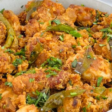 A dish of freshly cooked pakoras garnished with herbs.