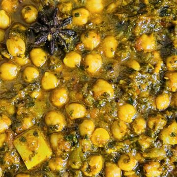 A bowl of Indian Palak chole (Chickpea Spinach Curry) seasoned with spices and herbs.