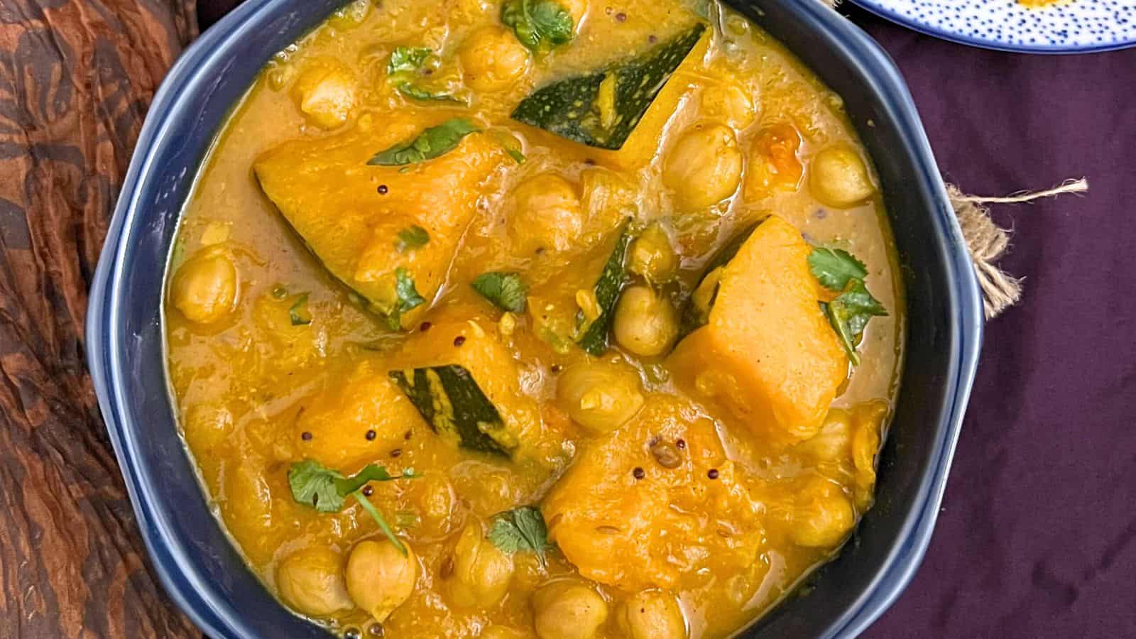 A bowl of Pumpkin Chickpea Curry with fresh herbs.