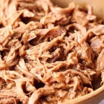 A bowl containing pulled pork.