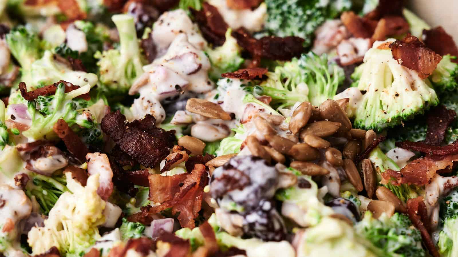 Close-up of a delightful broccoli salad with crispy bacon, sunflower seeds, and a creamy dressing. Mixed ingredients are visible in detail, showcasing the vibrant textures and colors of this fresh broccoli salad.