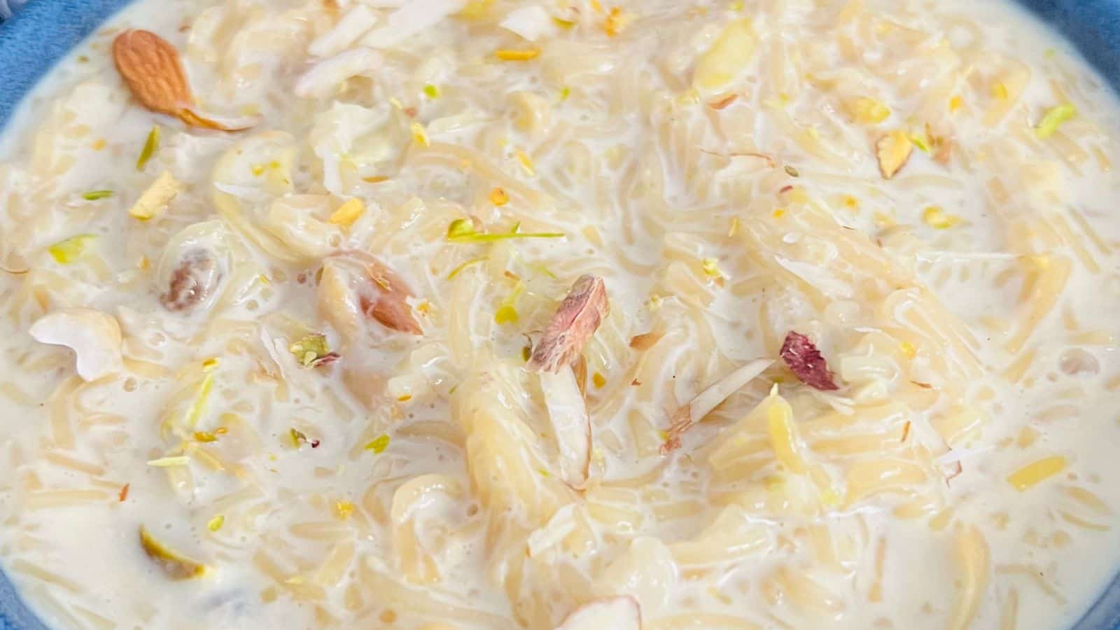 A bowl of semiya payasam, an indian dessert made with vermicelli noodles, milk, nuts, and garnished with almonds and pistachios.