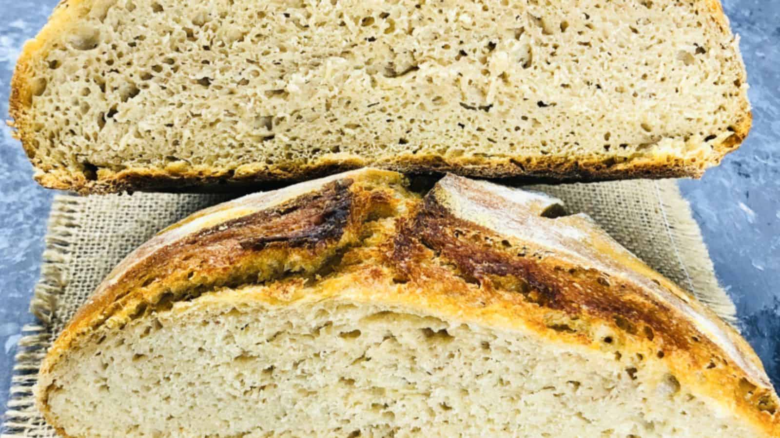 A close-up of a loaf of bread cut in half, displaying the crumb texture and crust details with one half resting above the other.