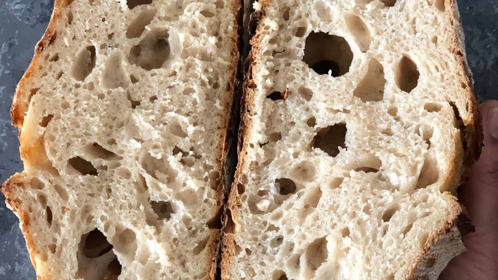 Close-up of a sliced loaf of bread with a coarse, airy texture and golden-brown crust.