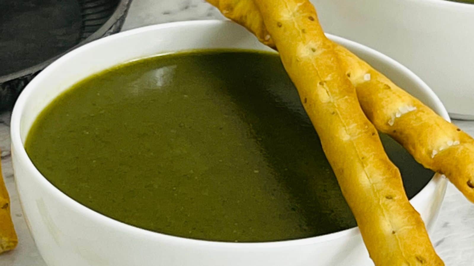 Palak soup served with bread sticks.